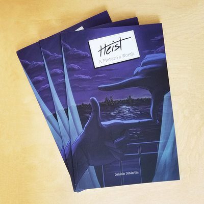 Stacked copies of the comic Heist: A Picture's Worth.